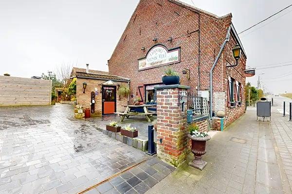 devanture de maison en briques, allée avec places de parking, terrasse extérieure