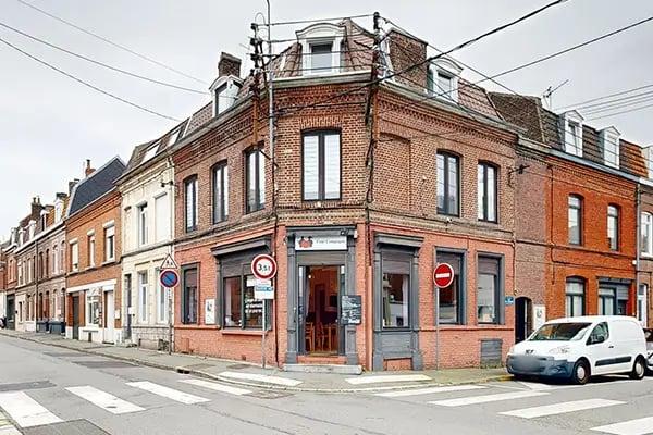 Coin de maison, façade en brique, enseigne de restaurant