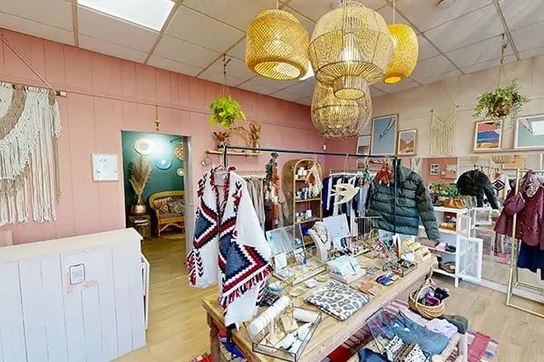 comptoir de caisse, suspensions, vêtements, accessoires, parquet en bois linéaire, étagères d'accessoires et cadres