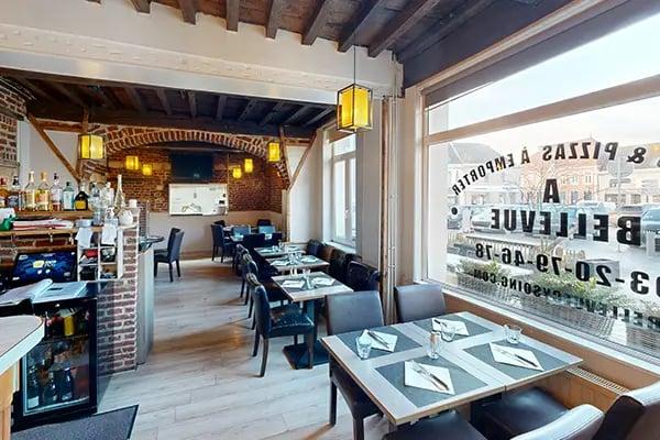 tables, chaises noires, poutres apparentes, briques, arche en cuisine